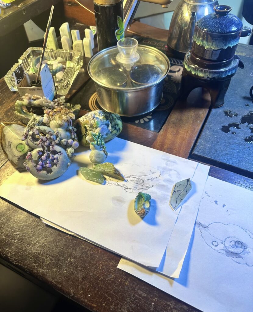 Jade carving schools compared: a carver working jadeite at the bench in the Ruili tradition